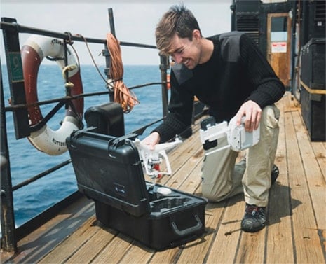 man on boat taking dji phantom out of waterproof drone case